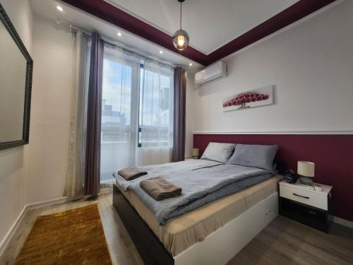 a bedroom with a bed and a large window at luxury Apartament TD one bedroom in Sofia