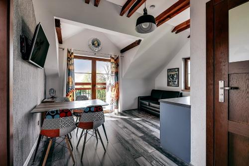 a kitchen and living room with a table and stools at Jantarvia Car Museum , Pasja i Wypoczynek Noclegi z Klimatem in Jantar