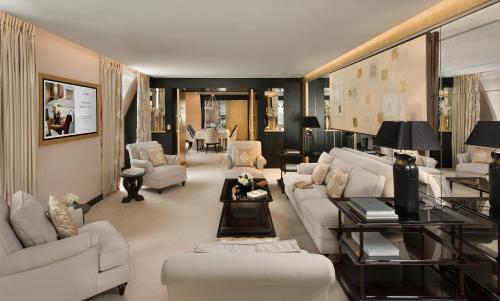 a living room with white couches and a table at Hôtel Barrière Fouquet's Paris in Paris
