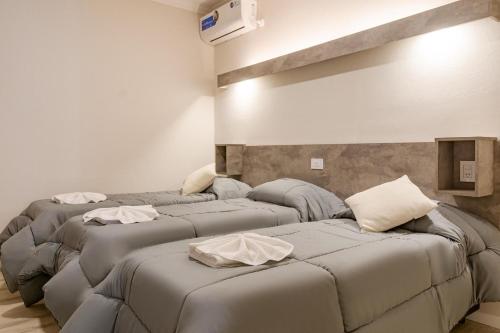a room with three beds with pillows on them at Brit Hotel in Villa Carlos Paz