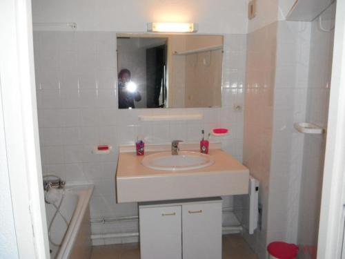 une personne prenant une photo d'une salle de bains avec lavabo dans l'établissement Estacade Lac et Océan, à Vieux-Boucau-les-Bains