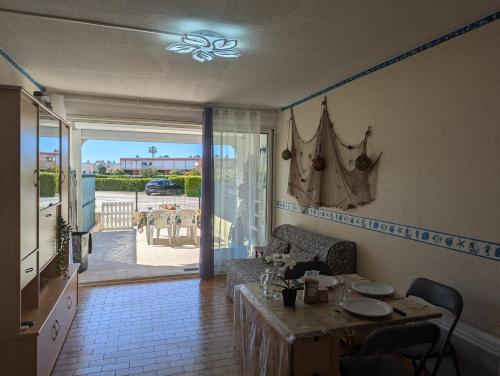 - un salon avec une table et une vue sur un patio dans l'établissement Sol-y-Days Canastel RDC avec parking, au Grau-du-Roi