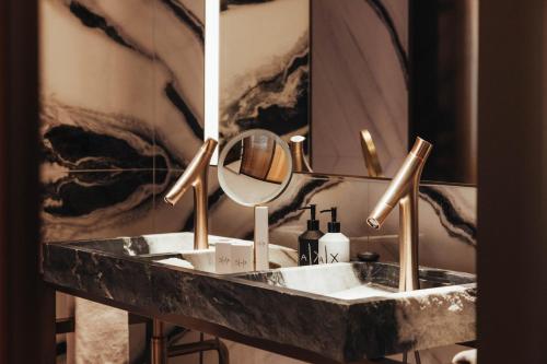 a bathroom with a marble sink and a mirror at Hotel SAX Paris, LXR Hotels & Resorts in Paris