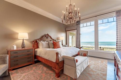a bedroom with a bed and a chandelier at 46 Surfsong Road by Akers Ellis Rentals in Kiawah Island
