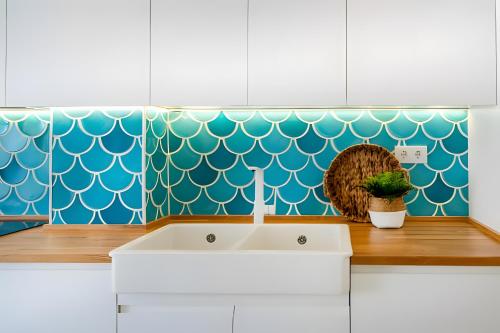 a kitchen with a white sink and a blue wall at Turquesa Y Sal in Matalascañas