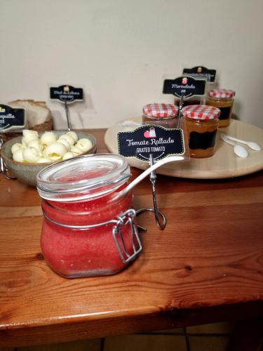 a table with a jar of jam and a plate of food at Hostal Remoña in Espinama