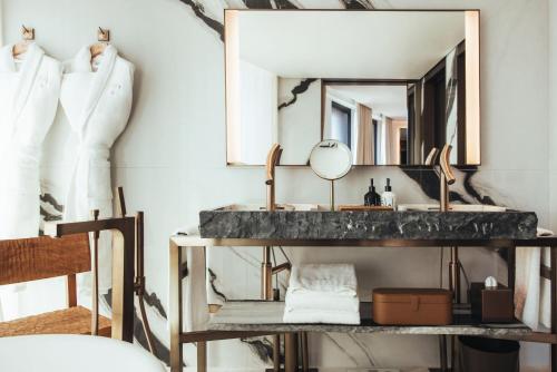 a bathroom with a sink and a mirror at Hotel SAX Paris, LXR Hotels & Resorts in Paris