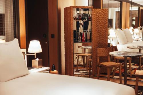 a bedroom with a bed and a table and chairs at Hotel SAX Paris, LXR Hotels & Resorts in Paris