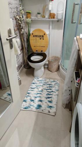 La salle de bains est pourvue de toilettes et d'un siège en bois. dans l'établissement Appartement très calme Aix en Provence, à Aix-en-Provence