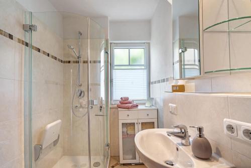 ブルンタールにあるFerienwohnung Alpencityの洗面台とガラスのシャワーを備えたバスルーム