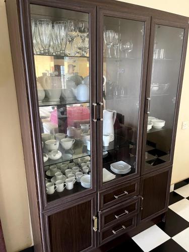 a wooden cabinet filled with plates and dishes at The Vatican Villa in Nuwara Eliya