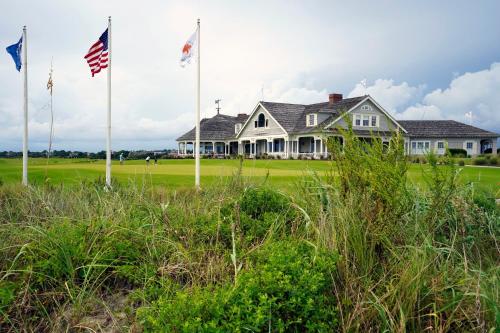 a house with two flags in front of a field at 4821 Turtle Cove Villa by Akers Ellis Rentals in Kiawah Island