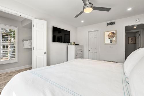 a white bedroom with a bed and a ceiling fan at 4821 Turtle Cove Villa by Akers Ellis Rentals in Kiawah Island