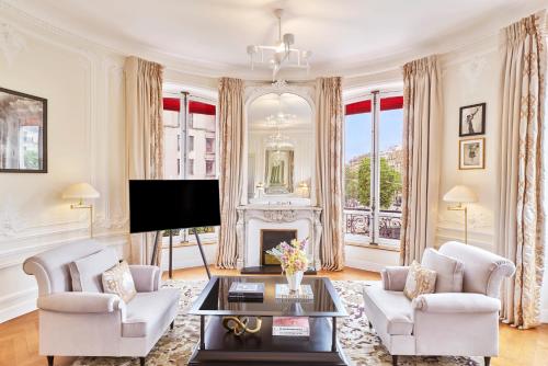 a living room with a fireplace and a tv at Hôtel Barrière Fouquet's Paris in Paris
