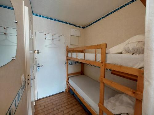 Cette chambre comprend 2 lits superposés et une porte. dans l'établissement Sol-y-Days Canastel RDC avec parking, au Grau-du-Roi