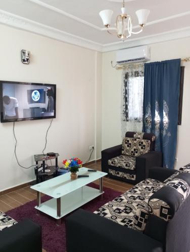 a living room with two couches and a tv at Golfe de Makepe in Douala