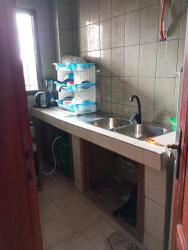 a kitchen counter with a sink and some paper towels at Golfe de Makepe in Douala