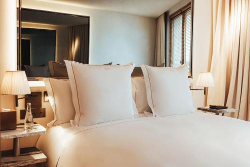 a bedroom with a large bed with white pillows at Hotel SAX Paris, LXR Hotels & Resorts in Paris