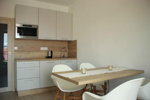 a kitchen with white cabinets and a table and chairs at Apartment Vyhlídka in Mikulov