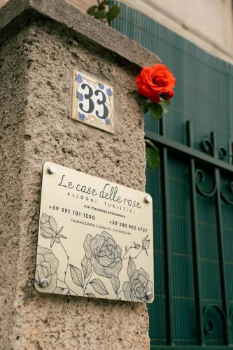 a sign on the side of a building with a rose at Le Case delle Rose in Civitavecchia