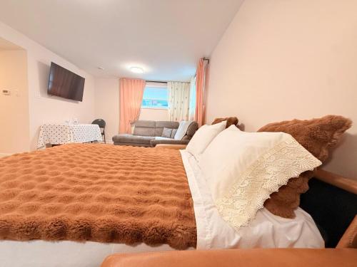 a bedroom with a large bed and a couch at Confort & Harmonie in Longueuil