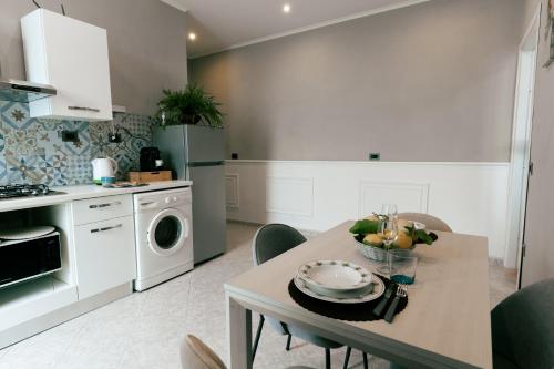 Una cocina con una mesa con un bol de fruta encima. en Le Case delle Rose, en Civitavecchia
