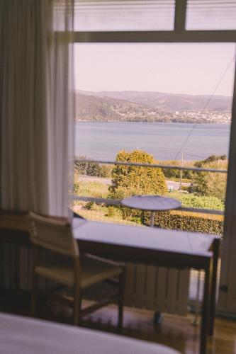 a window with a table and a view of the water at Hotel A Miranda in Feás