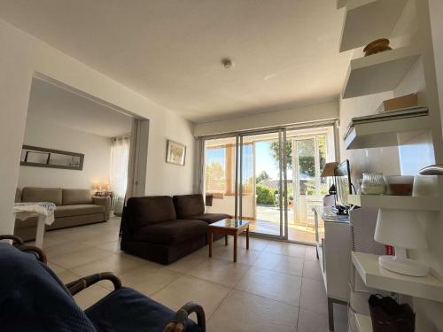 un salon avec un canapé et une table dans l'établissement Villa avec jardin, proche plages, 3 chambres, véranda, parking, wifi optionnel, Bormes-les-Mimosas - FR-1-308-27, à Bormes-les-Mimosas