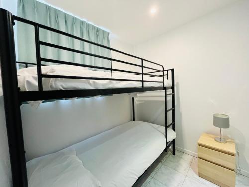 two bunk beds in a room with a night stand at Brasilia Hôtel in Palavas-les-Flots