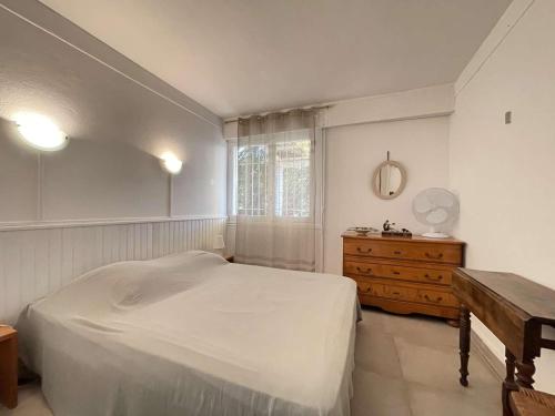 - une chambre avec un lit blanc et une commode en bois dans l'établissement Villa avec jardin, proche plages, 3 chambres, véranda, parking, wifi optionnel, Bormes-les-Mimosas - FR-1-308-27, à Bormes-les-Mimosas