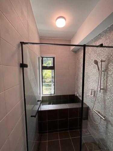 a bathroom with a shower with a tub and a window at Dawn Valley in Green Island