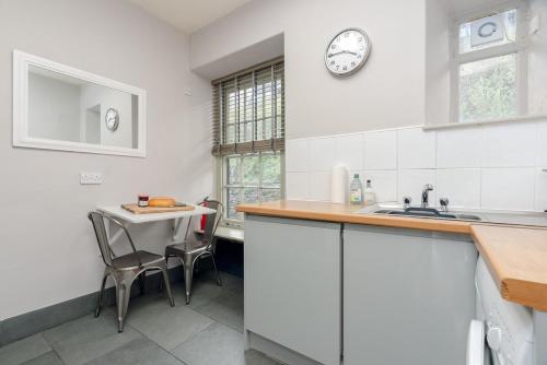 a kitchen with a table and a clock on the wall at Todd Crag - Amazing Views in Ambleside