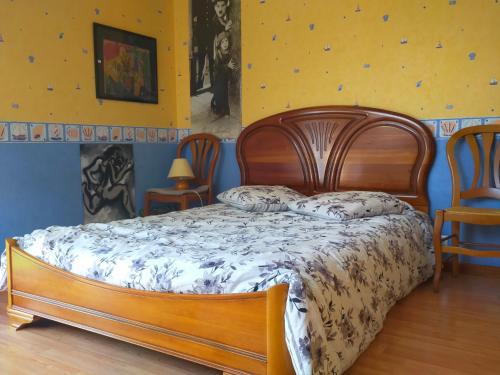 - un lit en bois dans une chambre avec 2 chaises dans l'établissement Entre Bretagne ET Normandie, à Avranches