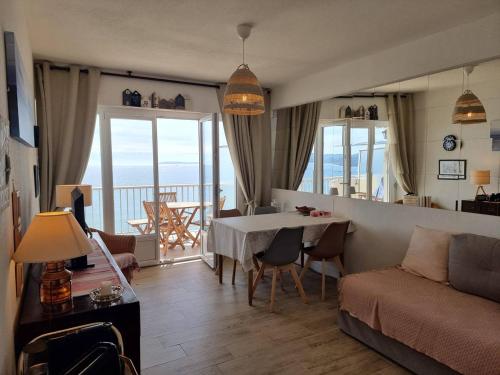 un salon avec un canapé et une table avec vue dans l'établissement Appartement en bord de mer avec Wi-Fi - Lavandou - FR-1-308-82, au Lavandou