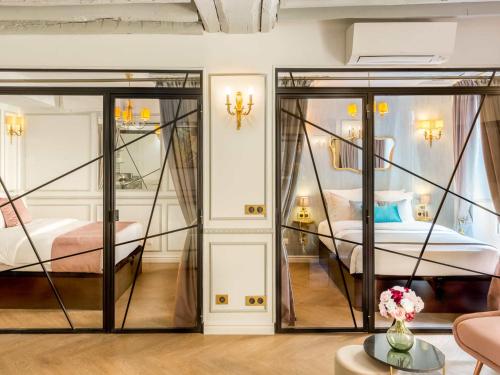 une chambre avec deux lits et un salon dans l'établissement Merveil - Luxury Suite - Louvre - Rambuteau, à Paris