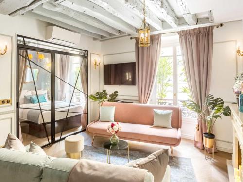 un salon avec un canapé et un lit dans l'établissement Merveil - Luxury Suite - Louvre - Rambuteau, à Paris