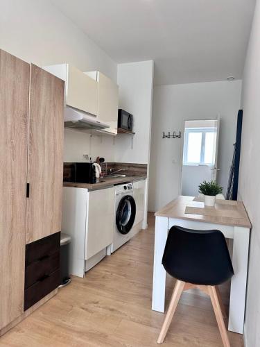 une petite cuisine avec un lave-linge et une table dans l'établissement L'Alsacien - Villeurbanne - Métro A et B, à Villeurbanne