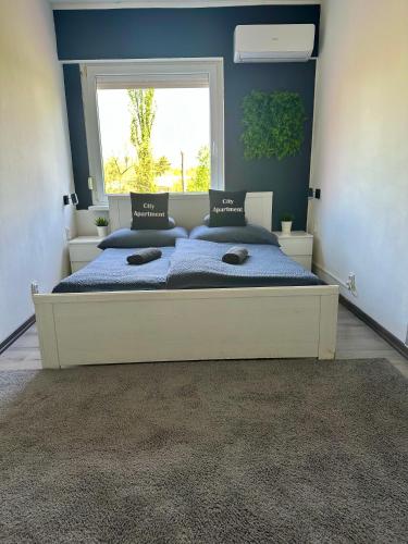 a bedroom with a large bed with a window at City Apartment in Štúrovo