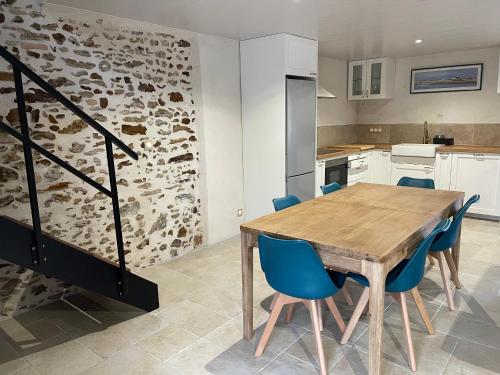 une cuisine avec une table en bois et des chaises bleues dans l'établissement Maison en pleine nature, à Salles