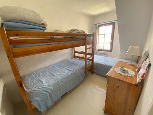 une chambre avec deux lits superposés et une table dans l'établissement Maison Normandie 19, à Fort-Mahon-Plage