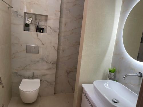a bathroom with a white toilet and a sink at Milto's Apartment in Limenaria