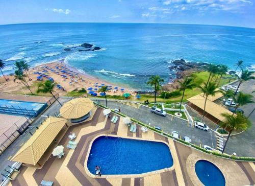 an aerial view of a resort with a pool and the beach at Ondina Apart Hotel 02 quartos Vista Mar in Salvador