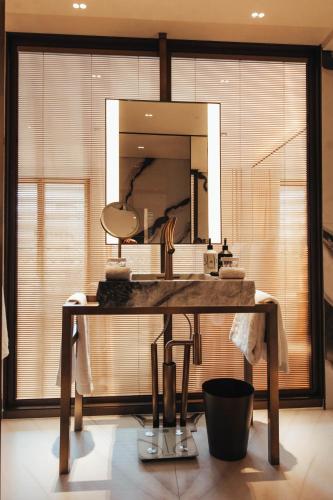 a bathroom with a large mirror and a sink at Hotel SAX Paris, LXR Hotels & Resorts in Paris