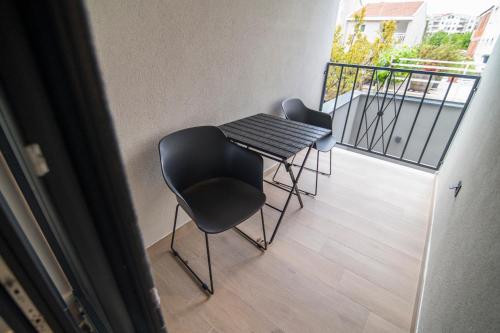 two chairs and a table on a balcony at Vila Luca in Mostar