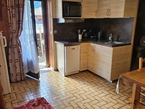 une cuisine avec un évier et une cuisinière four supérieur dans l'établissement Appartement cosy 4 pers, 50m télécabine & centre, balcon sud, parking, animaux ok - FR-1-676-95, à Châtel