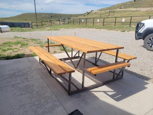 a picnic table and two benches on a street at Canyon Acres Ranch in Russell