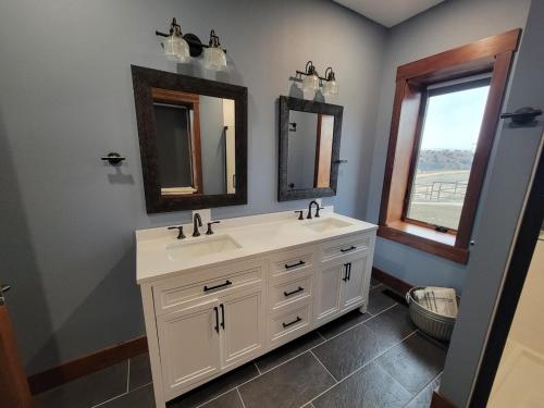 a bathroom with two sinks and two mirrors at Canyon Acres Ranch in Russell