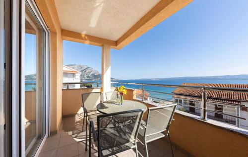 a balcony with a table and chairs and a view of the ocean at 1 Bedroom Amazing Apartment In Duce in Duće