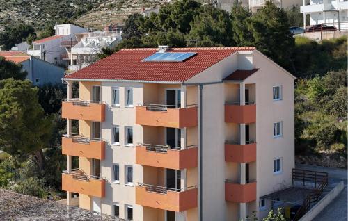 an apartment building with a red roof and a solarvisor at Stunning Apartment In Duce With Sea View in Duće