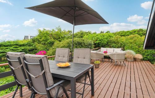 a table and chairs with an umbrella on a deck at Nice Home In Ebeltoft With Wifi in Ebeltoft